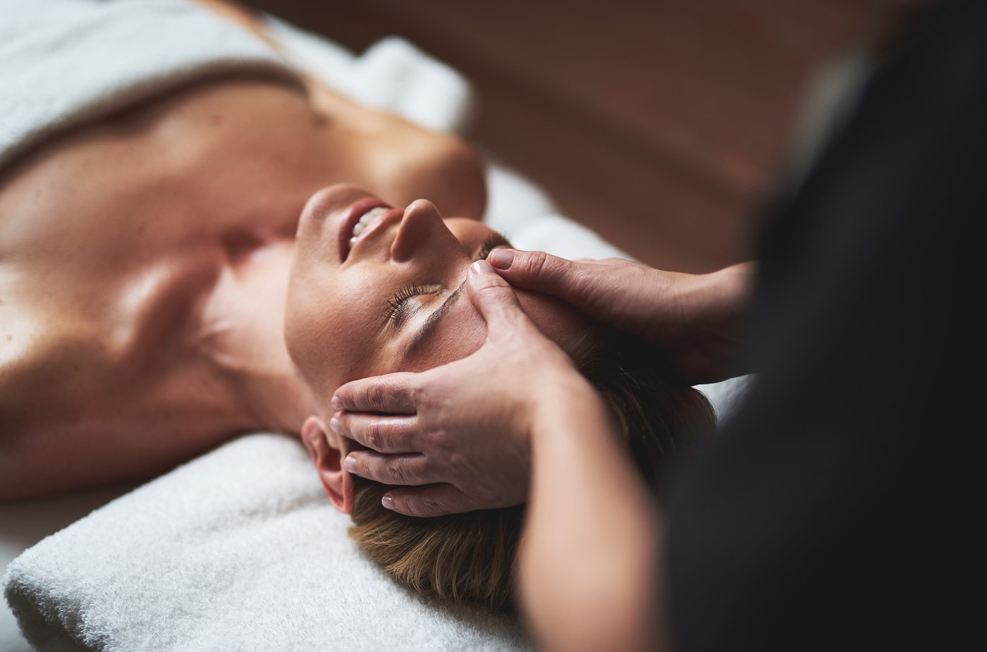 Therapist performing a facial massage on a client's cheeks and jawline